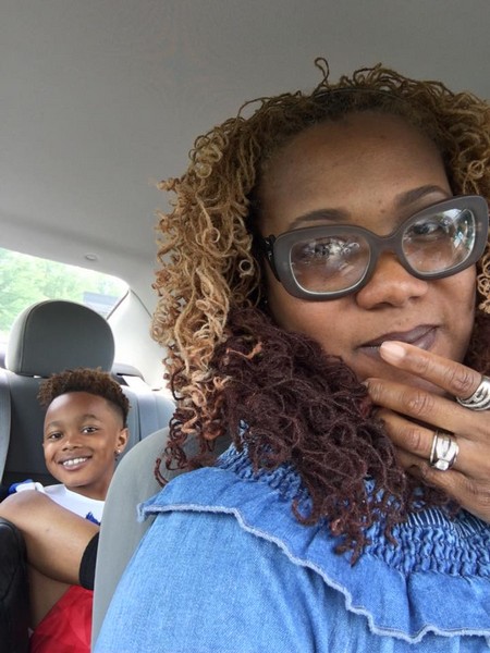 Lots of Locs client wearing styled locs with a smiling child