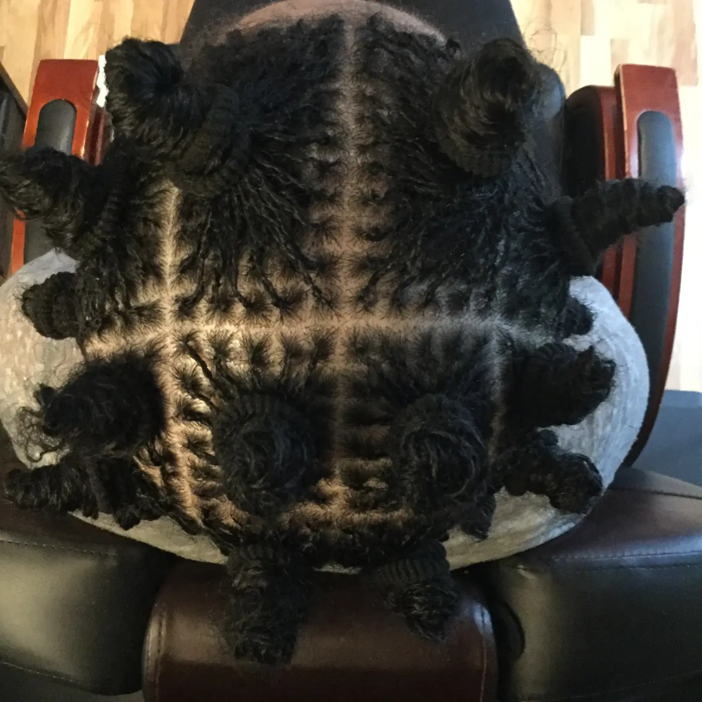 Close-up of a Sisterlocks installation in progress with clean sections and newly formed locs